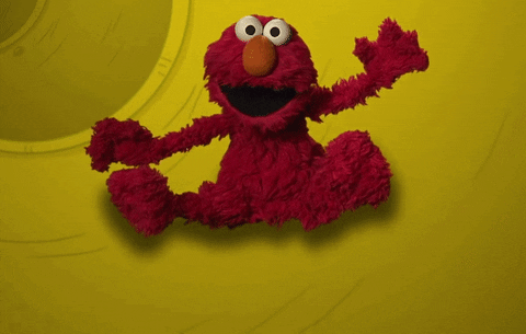 An animated GIF of Elmo from Sesame Street sliding down a tube